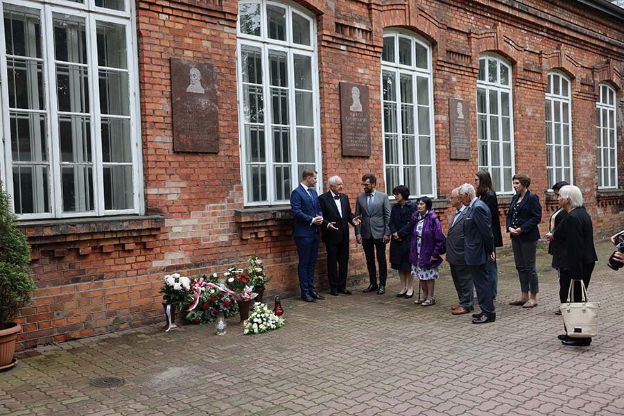 The laying flowers under the plaque commemorating August F. Wolff