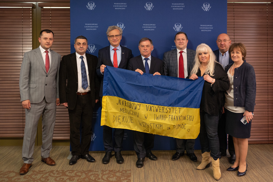Grupa ośmiu osób stoi trzymając flagę Ukrainy z napisem "Narodowy Uniwersytet Medyczny w Iwano-Frankiwsku diękuje wszystkim za pomoc"