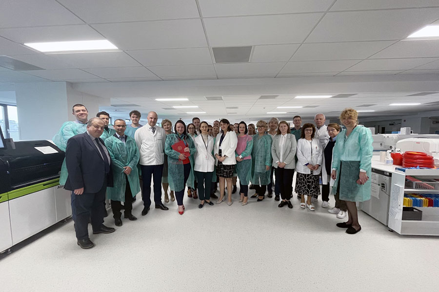 A group of people standing in a hospital laboratory. 