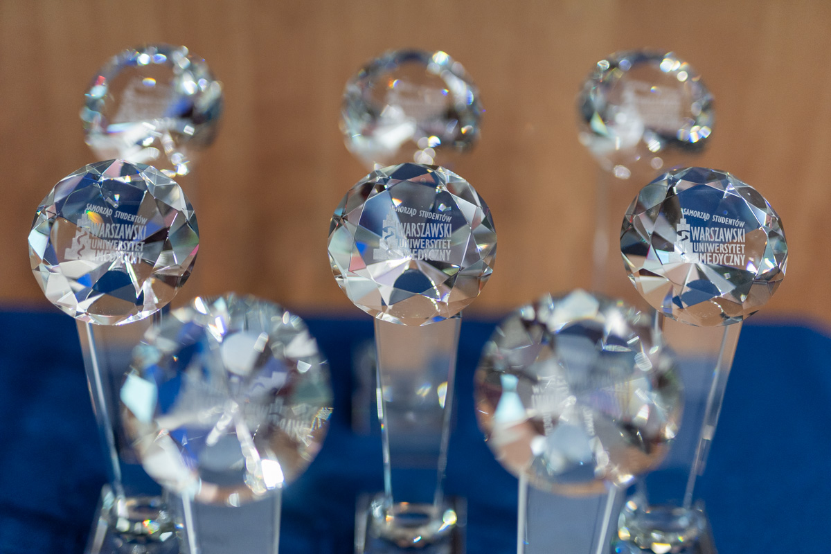 Crystal statuettes standing on a table covered with a navy blue tablecloth.