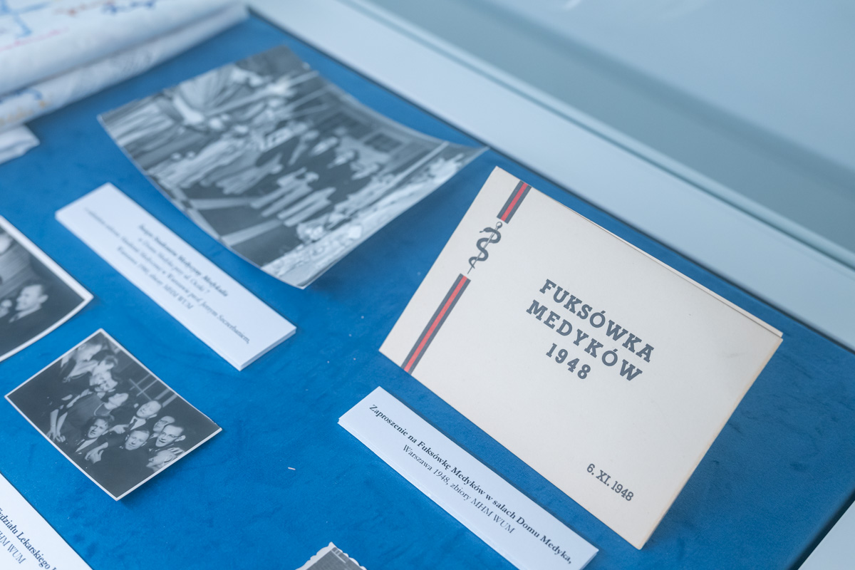 A section of a museum display case showing black‑and‑white photographs and a card labeled Fuksówka Medyków 1948.