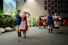Four couples in Polish folk costumes dance.