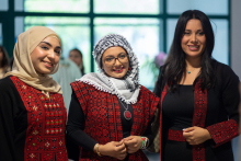 Three female students in traditional Arab costumes.