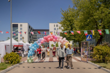 Ulica, na której ułożono kolorową "bramę" z balonów. Ulicą spacerują ludzie.