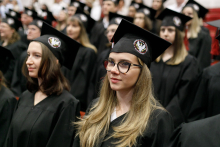 Graduation ceremony. Young people in black togas and birettas.