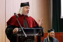 Graduation ceremony. A man (former dean) in a toga at the lectern.