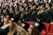 Graduation ceremony. Young people in black togas and birettas.