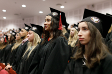 Young people in black togas and birettas.