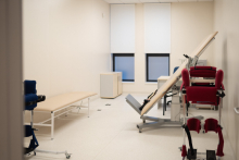 Pomieszczenie do rehabilitacji na oddziale, przy ścianach sprzęt do ćwiczeń, stoły do masażu