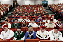 A collection of people of different ages dressed in academic clothing of different colours