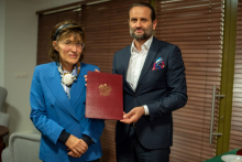 A woman and a man. The man is holding a diploma