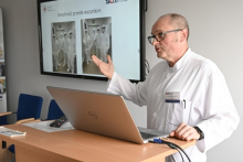 Man at the lectern wearing a doctor's apron