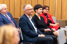 Four people visible - in the front row two women and one man. In the row behind them a man.