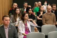 Goście konferencji o chorobach rzadkich. Grupa osób w różnym wieku, siedzą na krzesłach w sali konferencyjnej.