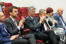 Grupa osób, uczestników konferencji, siedzących w auli wykładowej. Biją brawa.