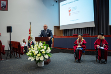 A man is speaking at a podium during the graduation ceremony.