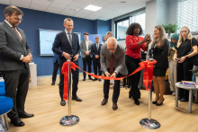 The rector cutting the ribbon. Behind him and beside him stand the other participants of the event.