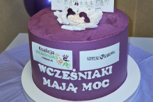 Fioletowy tort z białym napisem "Wcześniaki mają moc".
