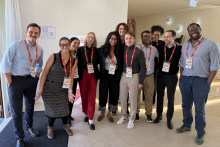 Grupa dziesięciu osób. Szósty od lewej jest Adrian Bednarek. Wszyscy uśmiechają się do zdjęcia, są nieformalnie ubrani.