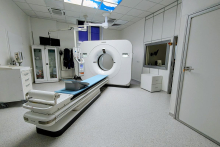 A modern CT scanner in a bright, sterile medical room.