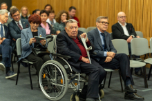 The event participants who are seated on chairs.
