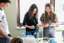 Participants in laparoscopic training working with a surgical simulator, using endoscopic instruments to perform precise movements over the training station.