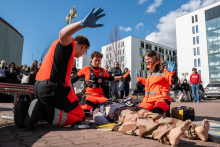 Participants in laparoscopic training working with a surgical simulator, using endoscopic instruments to perform precise movements over the training station.