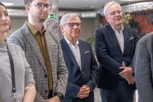 Kilka osób stojących w korytarzu.