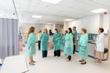 A group of people in hospital coats in a hospital corridor.