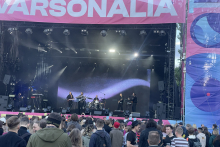 Szeroki widok na scenę plenerową z występującym zespołem oraz dużą grupą uczestników wydarzenia zgromadzonych przed sceną. Widoczna infrastruktura koncertowa i nagłośnienie.