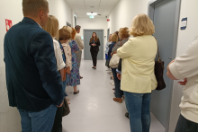 Kilkanaście osób stoi w korytarzu w Centrum Symulacji Medycznych.
