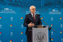 Osoba przemawia przy mównicy podczas wydarzenia organizowanego przez Uniwersyteckie Centrum Kliniczne WUM.