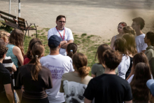 Participants conversing outdoors in front of a building during a break between activities.