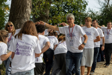 Participants taking part in a team-building activity outdoors beneath large trees.