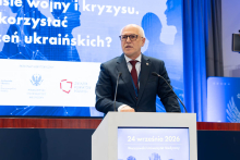 Conference speaker addressing attendees from a podium during a session at Warsaw Medical University.