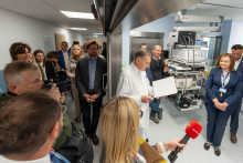Event participants listen to a presentation in a room equipped with specialized medical devices.
