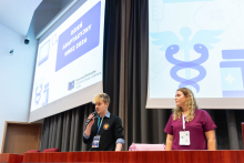 Dwie osoby stoją na scenie podczas prezentacji otwierającej Dzień Adaptacyjny WNoZ 2026. Za nimi wyświetlona jest prezentacja multimedialna.