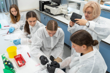 Prowadząca nadzoruje wykonywanie ćwiczenia laboratoryjnego przez uczestników pracujących przy stole laboratoryjnym.