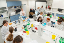 Widok laboratorium, w którym kilka zespołów uczestników jednocześnie wykonuje ćwiczenia praktyczne.