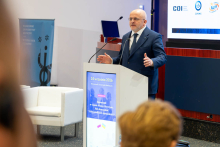 Jedna osoba przemawia z mównicy podczas konferencji.