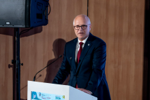 Rektor WUM stoi za mównicą i przemawia.