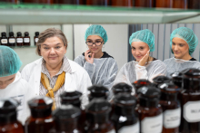 Prowadząca omawia przebieg ćwiczeń laboratoryjnych z grupą uczestników ubranych w odzież ochronną.