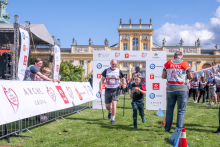 An adult participant and a child move along the event route in the grounds of the Wilanów Palace. Other participants are visible in the background.