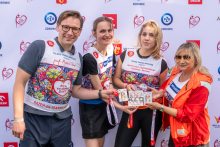 Four participants pose for a photo in front of the event backdrop and display commemorative medals from the “31st Run for New Life – Warsaw 2026”.