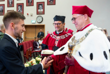A student receives congratulations from a representative of the university authorities during the ceremony.