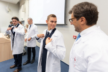People wearing white coats on stage.