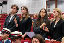 Doctoral students stand among the audience and take the oath during the academic year inauguration ceremony.