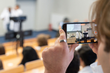A person takes a photo with a mobile phone during the ceremony.