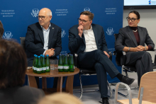 przy stoliku siedzą i przysłuchują się wystąpieniu rektor WUM, prorektor i dyrektorka UCK WUM