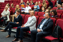 Participants of the Pharmacovigilance Polska 2026 Congress seated in red auditorium chairs and watching the event.